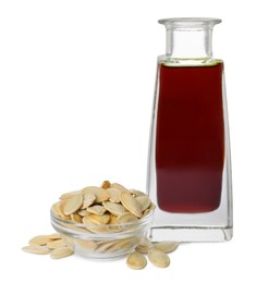 Photo of Fresh pumpkin seed oil in glass bottle and kernels isolated on white
