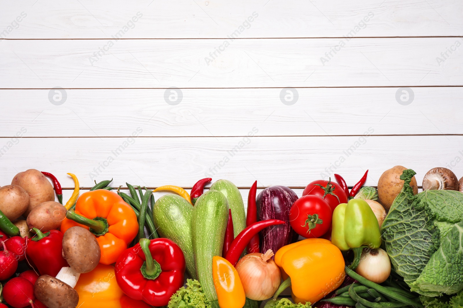 Photo of Different fresh vegetables on white wooden table, flat lay. Space for text