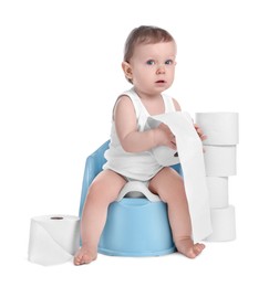 Photo of Little child sitting on baby potty and stack of toilet paper rolls against white background