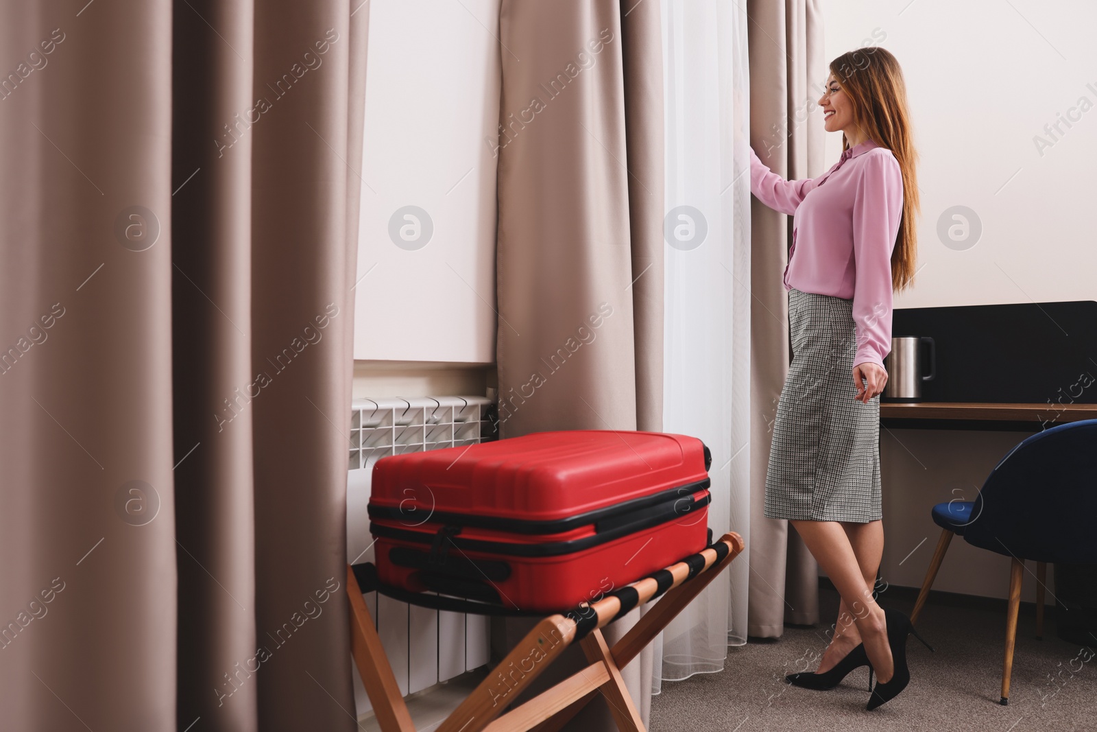 Photo of Beautiful businesswoman near window in hotel room