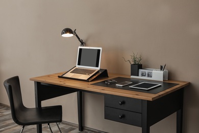 Modern workplace interior with laptop and devices on table. Space for text