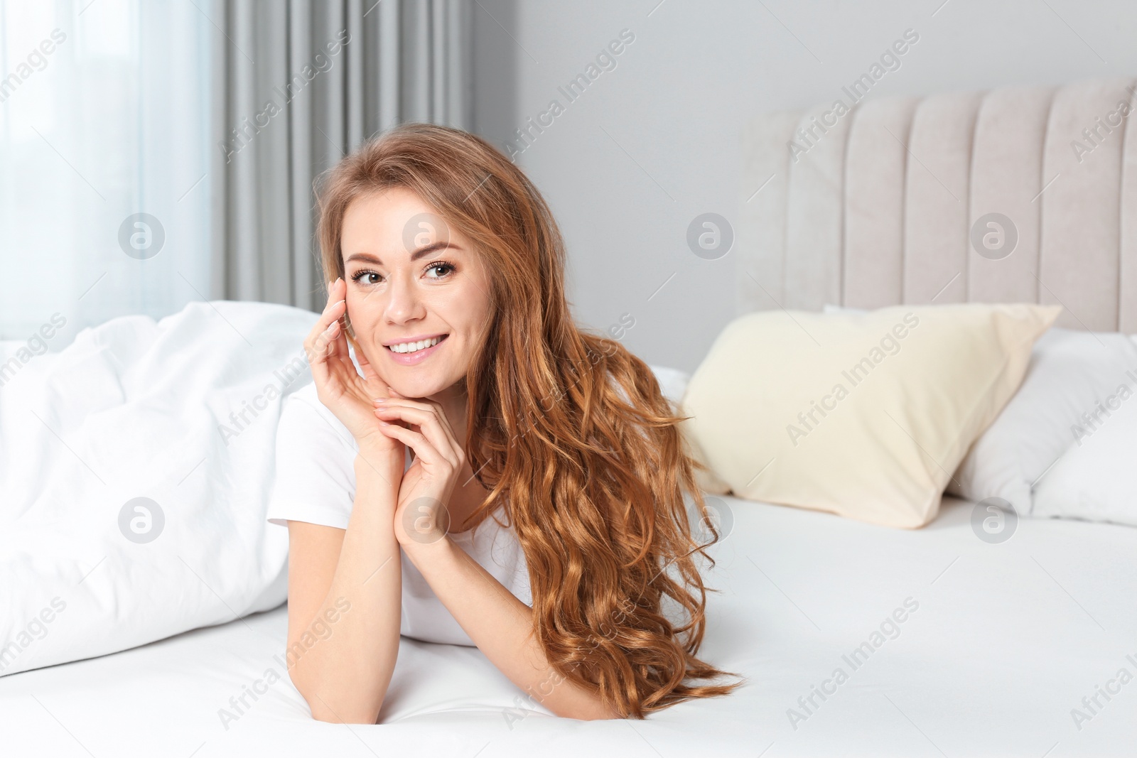 Photo of Portrait of happy beautiful woman on bed at home