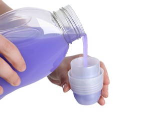 Photo of Woman pouring fabric softener from bottle into cap on white background, closeup