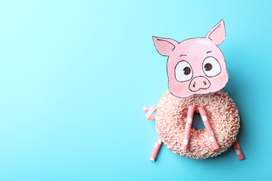 Photo of Funny pig made with donut and straws on light blue background, flat lay. Space for text