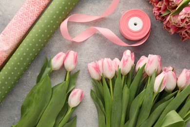 Beautiful pink tulips on grey table, flat lay