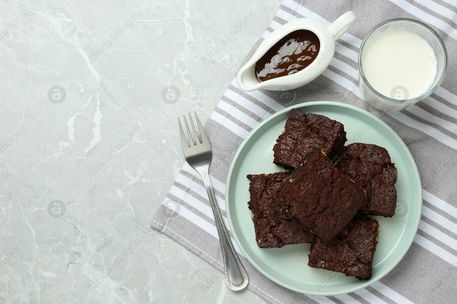 Photo of Delicious chocolate brownies with nuts on light grey table, flat lay. Space for text