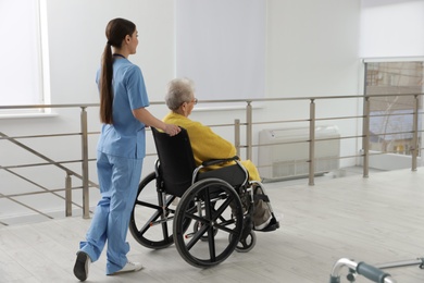 Nurse assisting senior woman in wheelchair at hospital