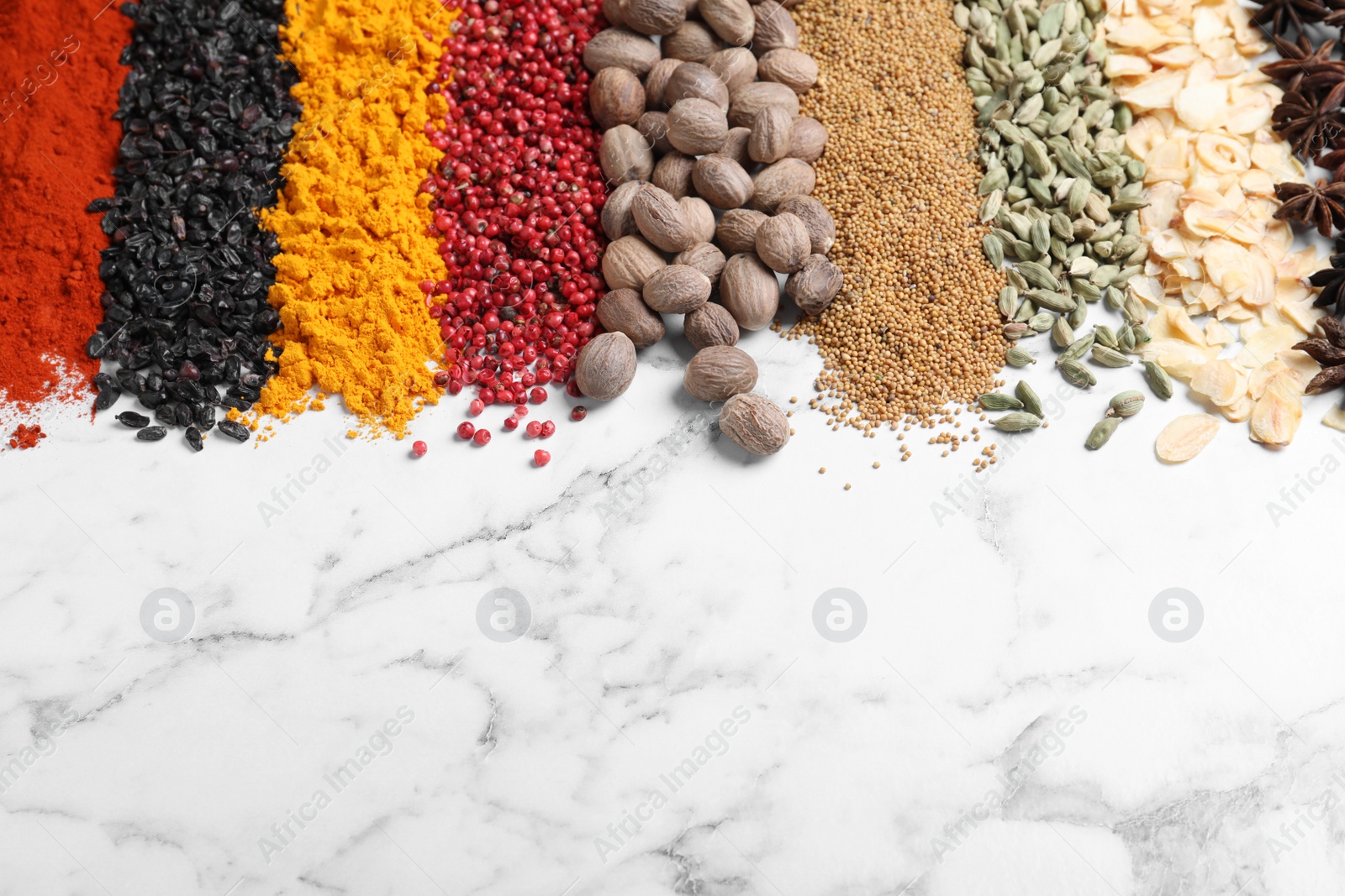 Photo of Many different spices on white marble background. Space for text