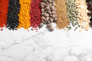 Many different spices on white marble background. Space for text
