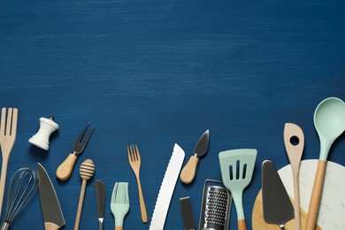 Set of different kitchen utensils on blue wooden table, flat lay. Space for text