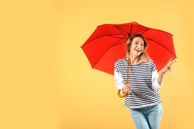 Woman with red umbrella on color background