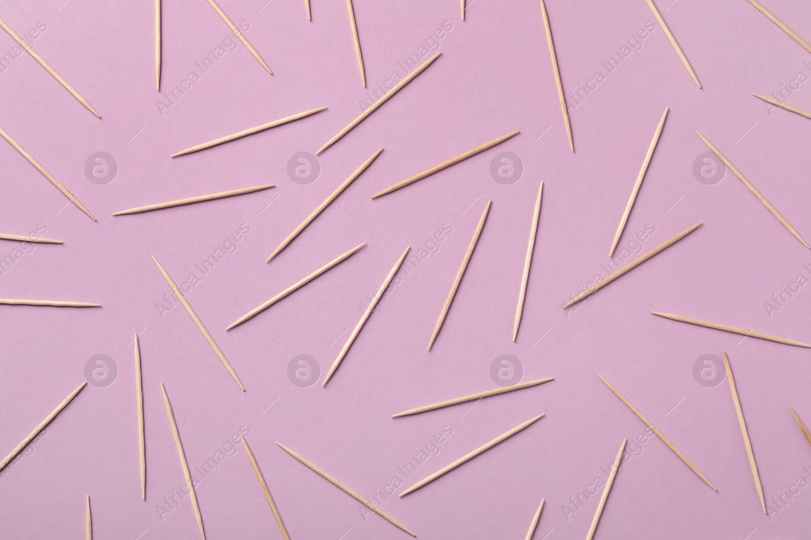 Photo of Wooden toothpicks on pink background, flat lay