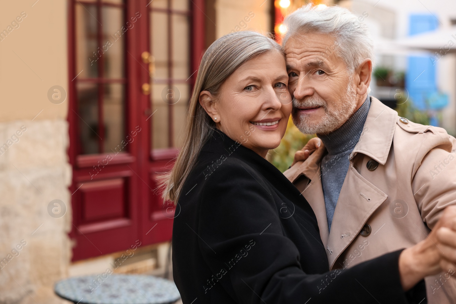 Photo of Affectionate senior couple dancing together outdoors, space for text