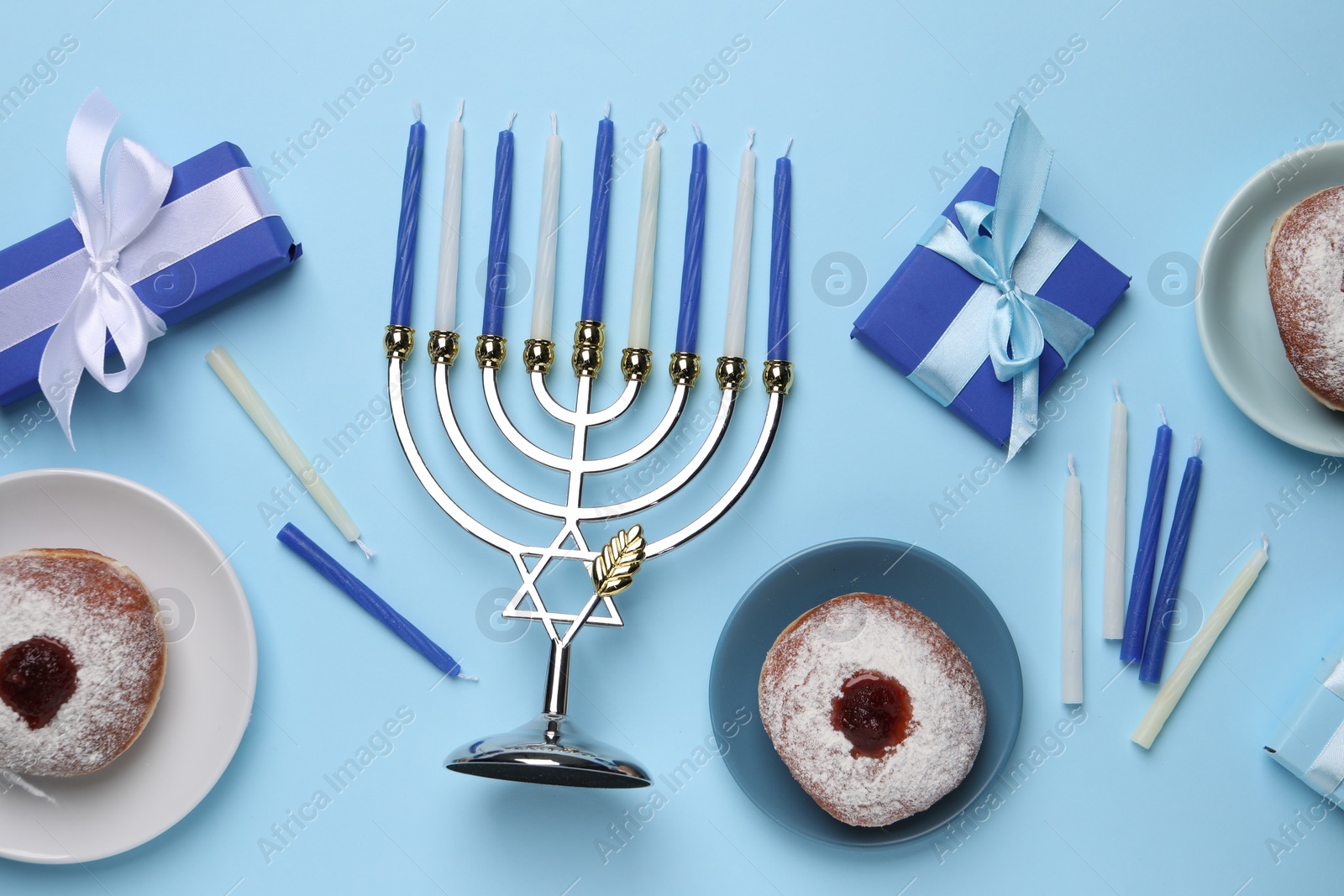 Photo of Flat lay composition with Hanukkah menorah and donuts on light blue background