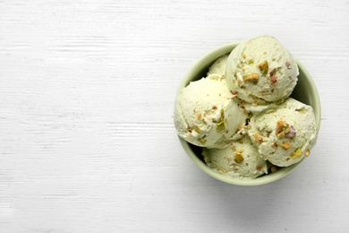 Tasty pistachio ice cream on white wooden table, top view. Space for text