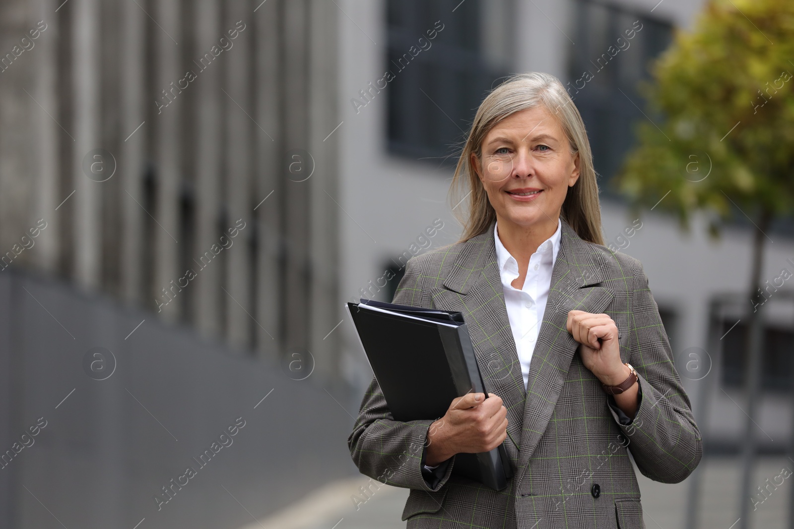 Photo of Beautiful woman with folders outdoors, space for text. Lawyer, businesswoman, accountant or manager