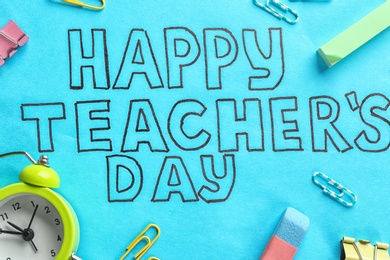 Photo of Alarm clock, text HAPPY TEACHER'S DAY and stationery on color paper