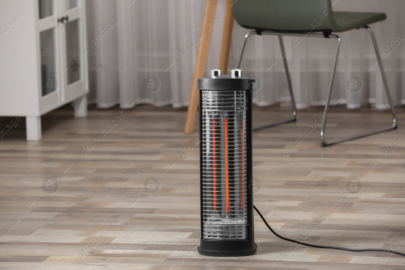 Photo of Modern infrared heater on floor in room