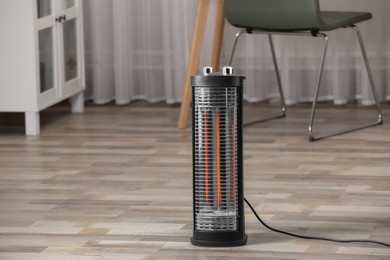 Photo of Modern infrared heater on floor in room