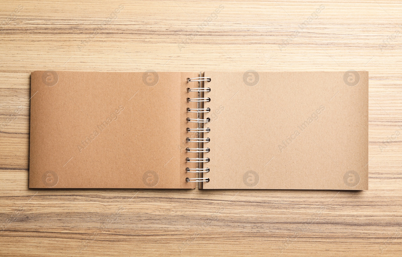 Photo of Stylish open notebook on wooden table, top view. Space for design