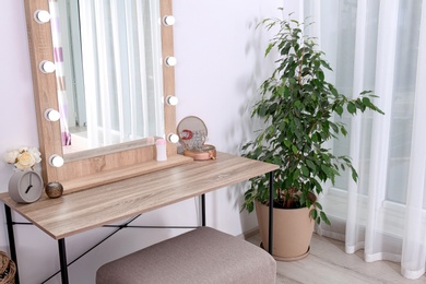 Photo of Stylish room interior with dressing table and potted ficus