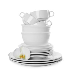 Photo of Set of dishware and flower on white background