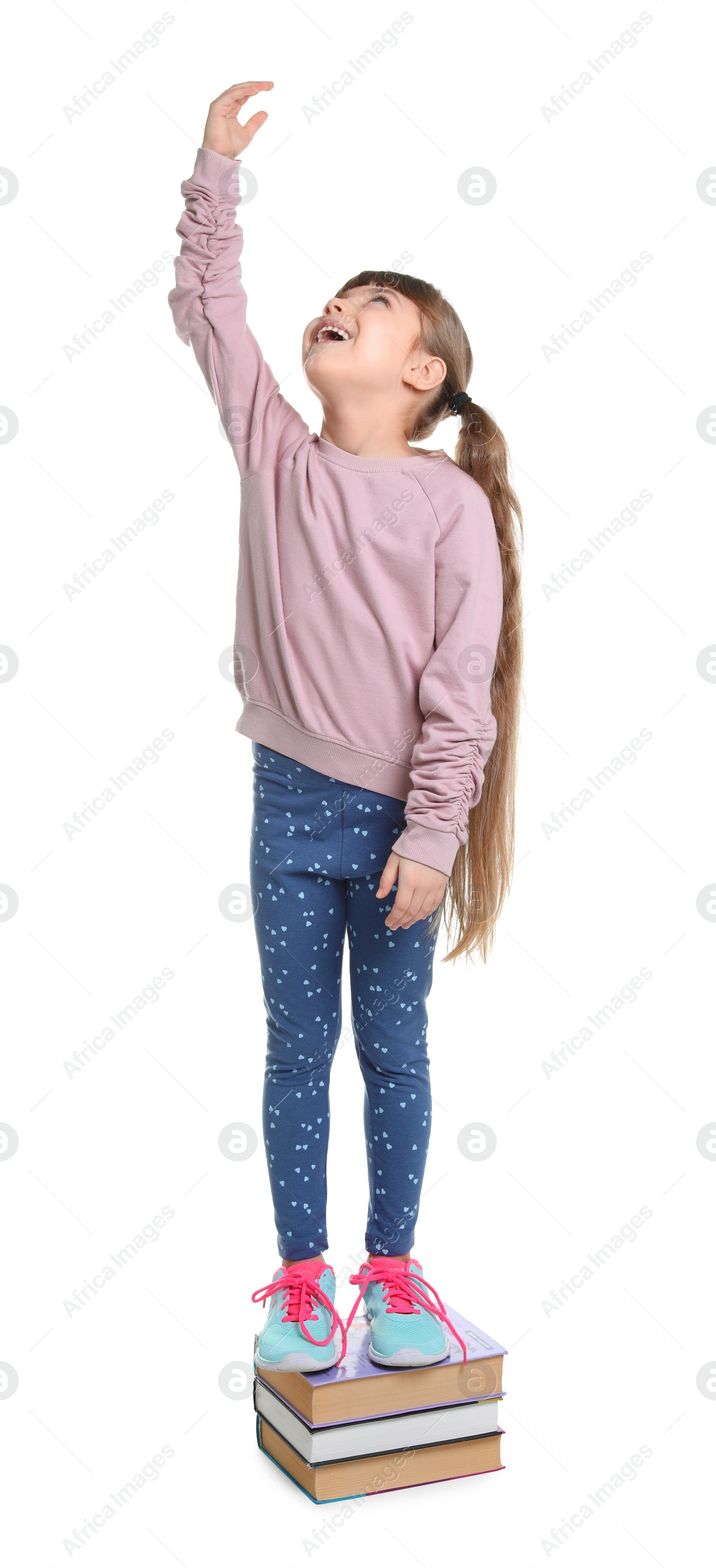 Photo of Little girl measuring her height on white background