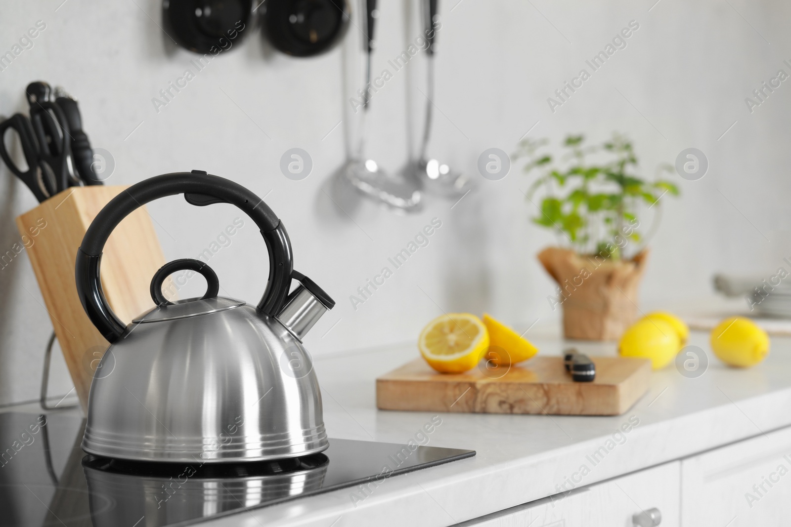 Photo of Stylish kettle with whistle on cooktop in kitchen. Space for text