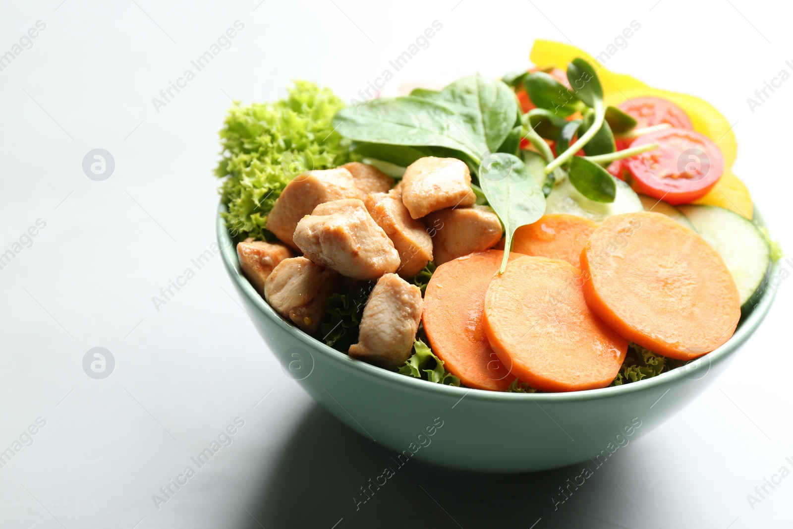 Photo of Delicious fresh chicken salad served on grey table, closeup