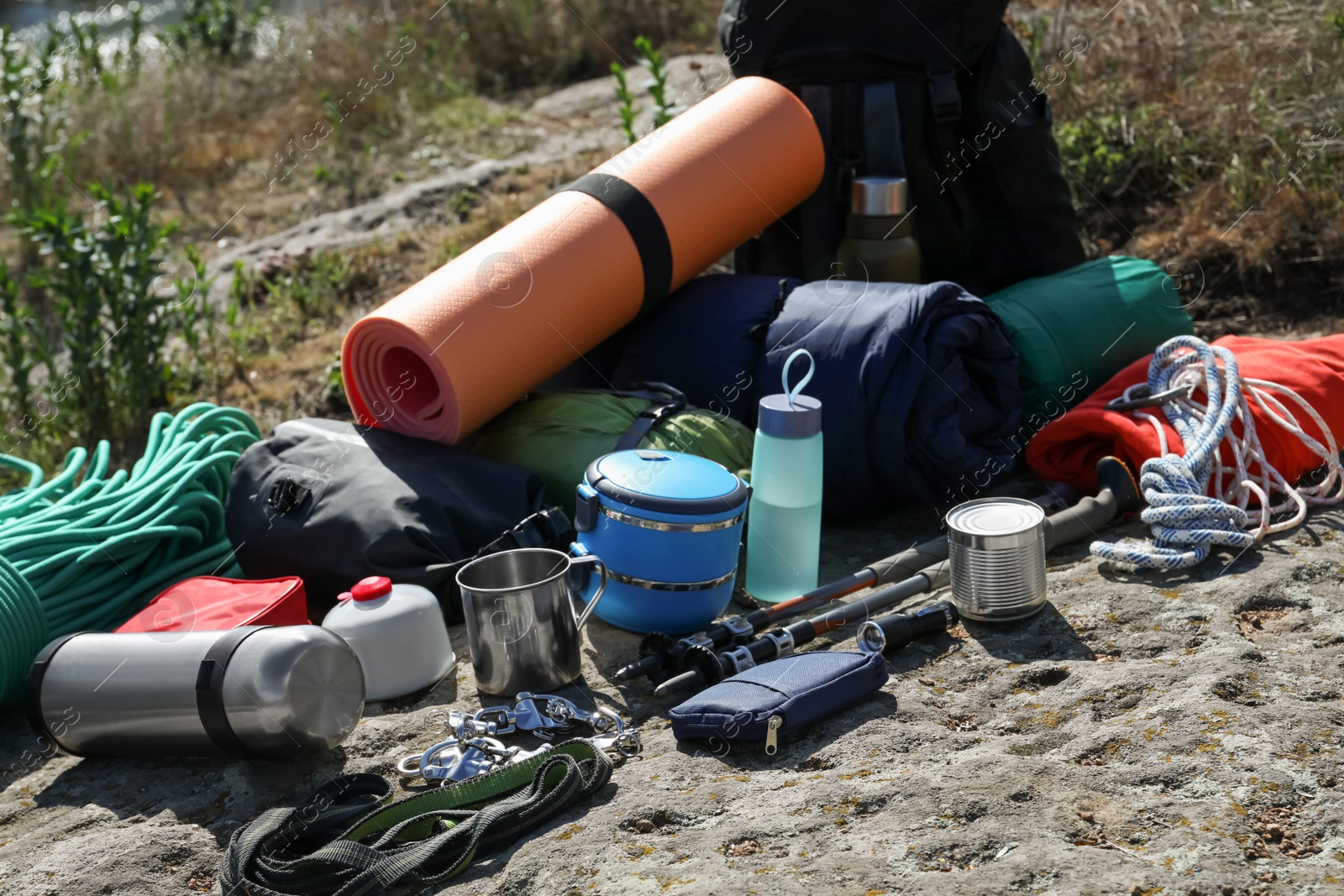 Photo of Backpack with hiking equipment on rock outdoors