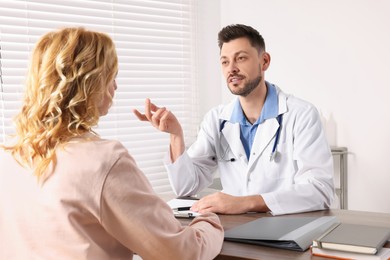 Doctor consulting patient at table in clinic