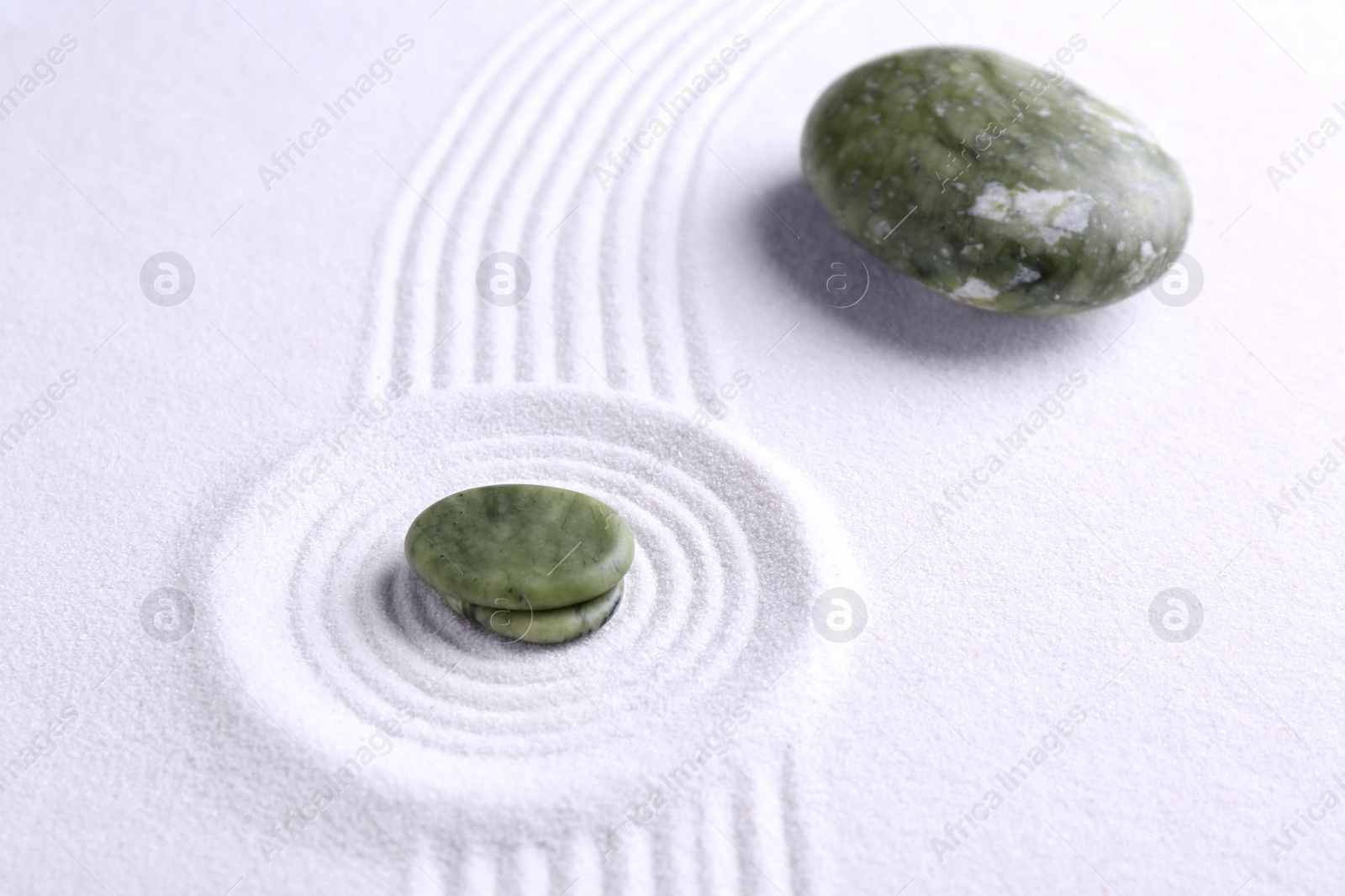 Photo of Zen concept. Stones and pattern on white sand