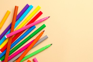 Photo of Many bright markers on beige background, flat lay. Space for text