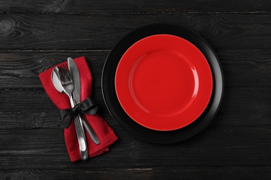 Beautiful table setting on black wooden background, flat lay