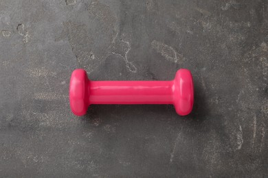Photo of One pink dumbbell on grey table, top view