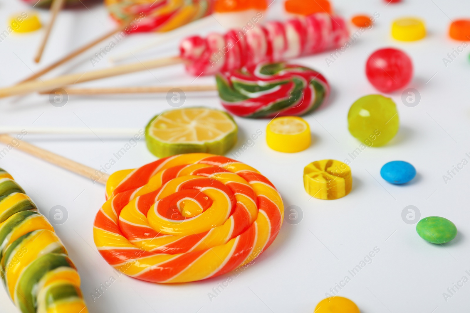 Photo of Many different candies on white background, closeup view