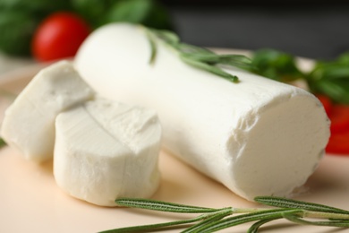 Photo of Delicious goat cheese with rosemary on plate, closeup