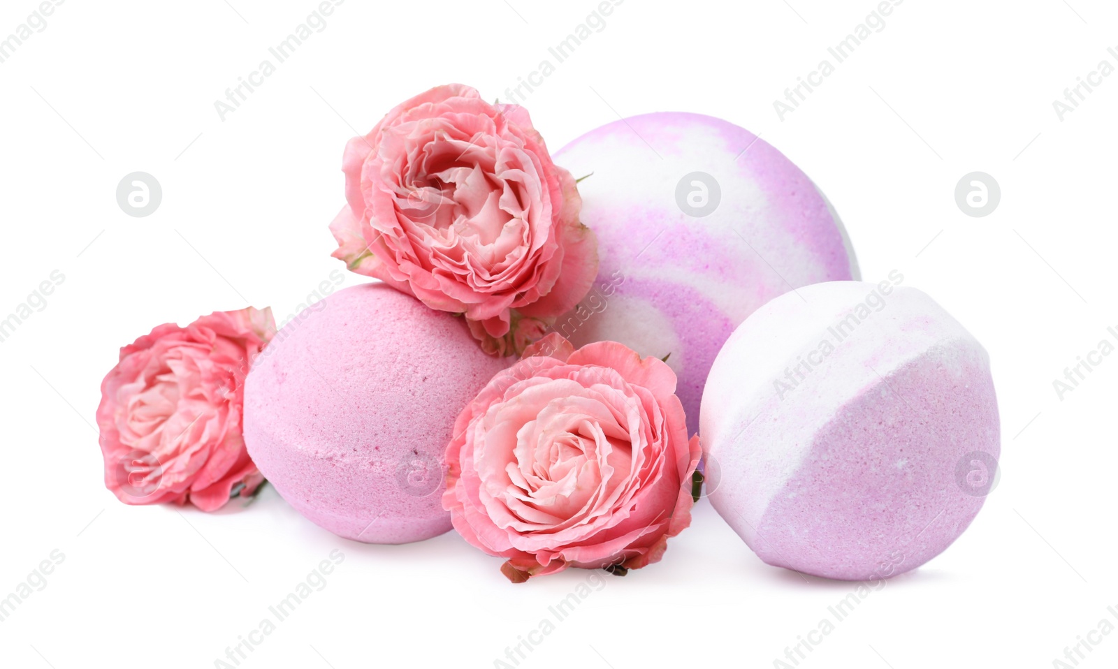 Photo of Fragrant bath bombs and rose flowers on white background