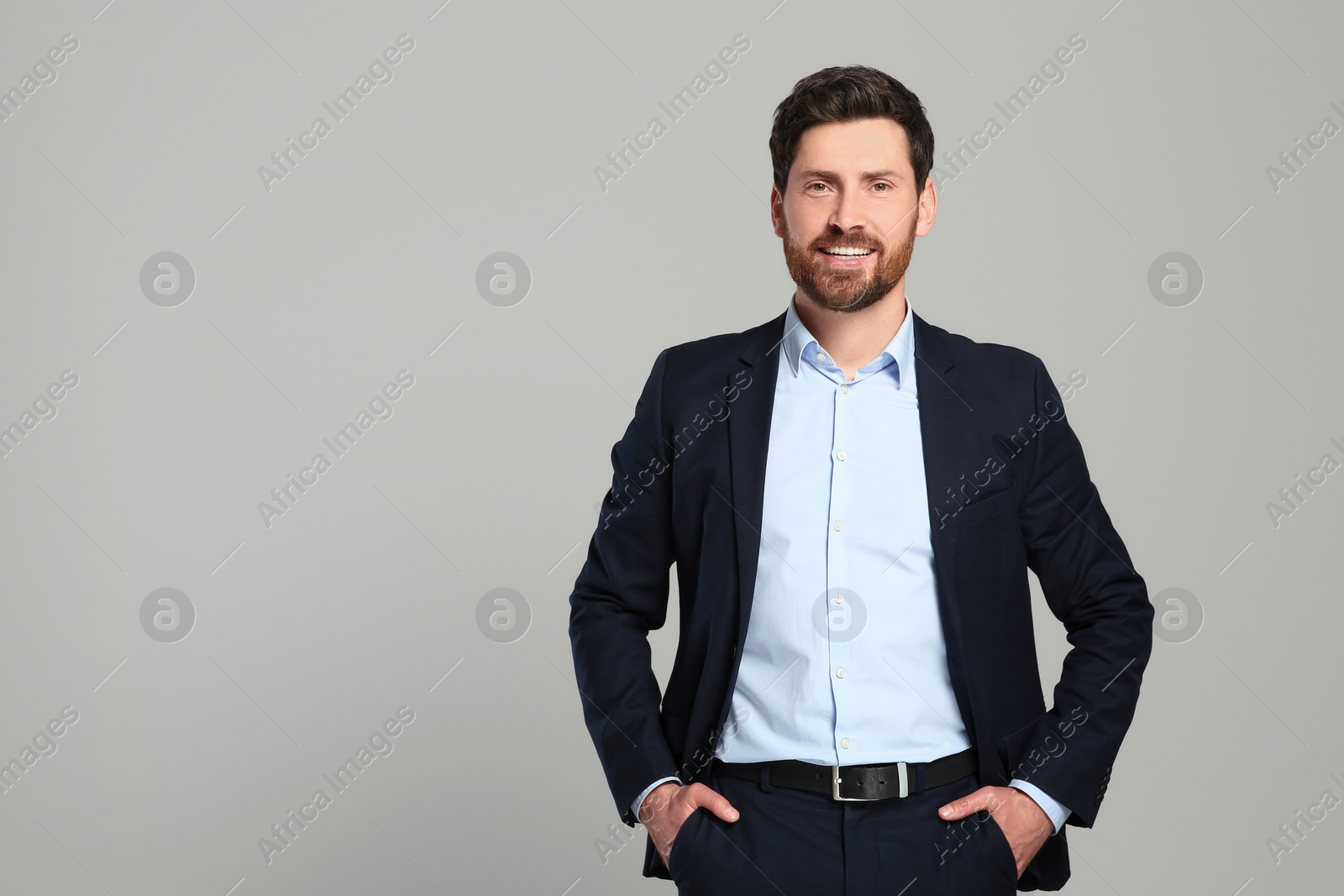 Photo of Handsome real estate agent in nice suit on grey background, space for text