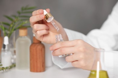 Photo of Dermatologist testing essential oil indoors, selective focus