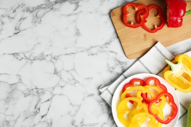 Photo of Flat lay composition with cut ripe bell peppers on marble table, space for text