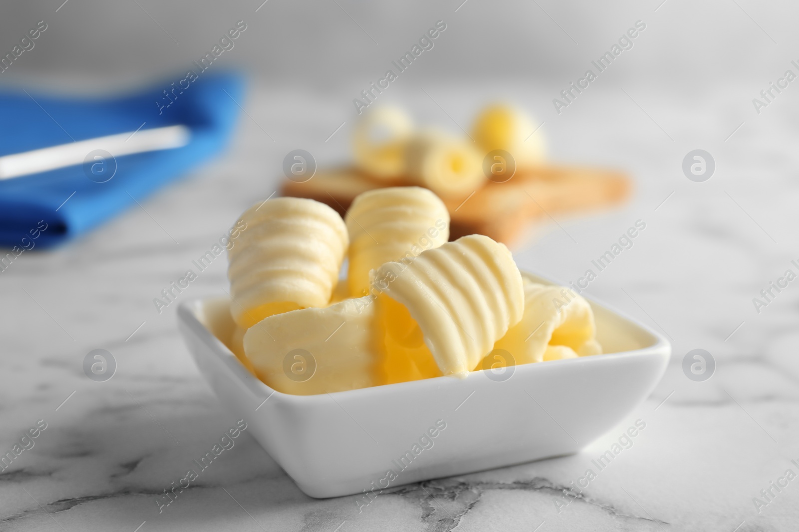 Photo of Gravy boat with butter curls on table, closeup