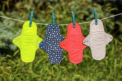 Many different menstrual cloth pads hanging on rope outdoors