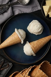 Ice cream scoops in wafer cones on table, flat lay