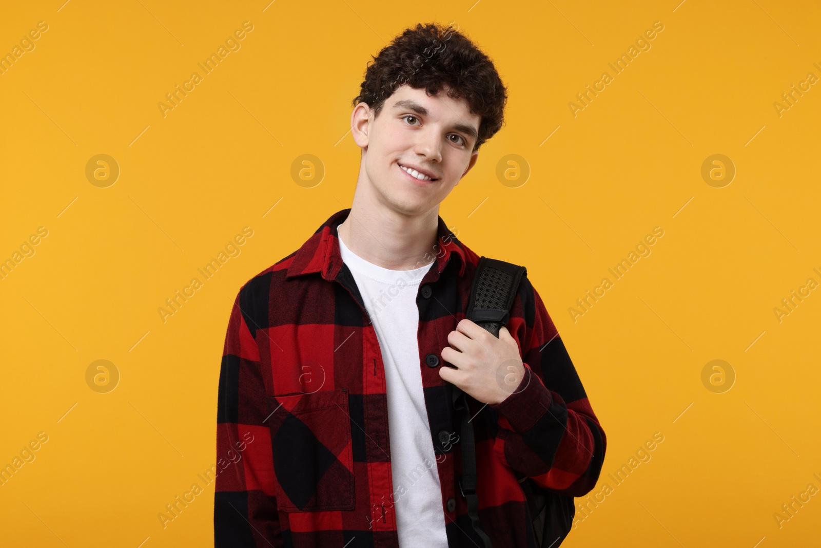 Photo of Portrait of student with backpack on orange background