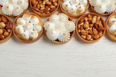 Photo of Many different tartlets on white wooden table, top view and space for text. Delicious dessert