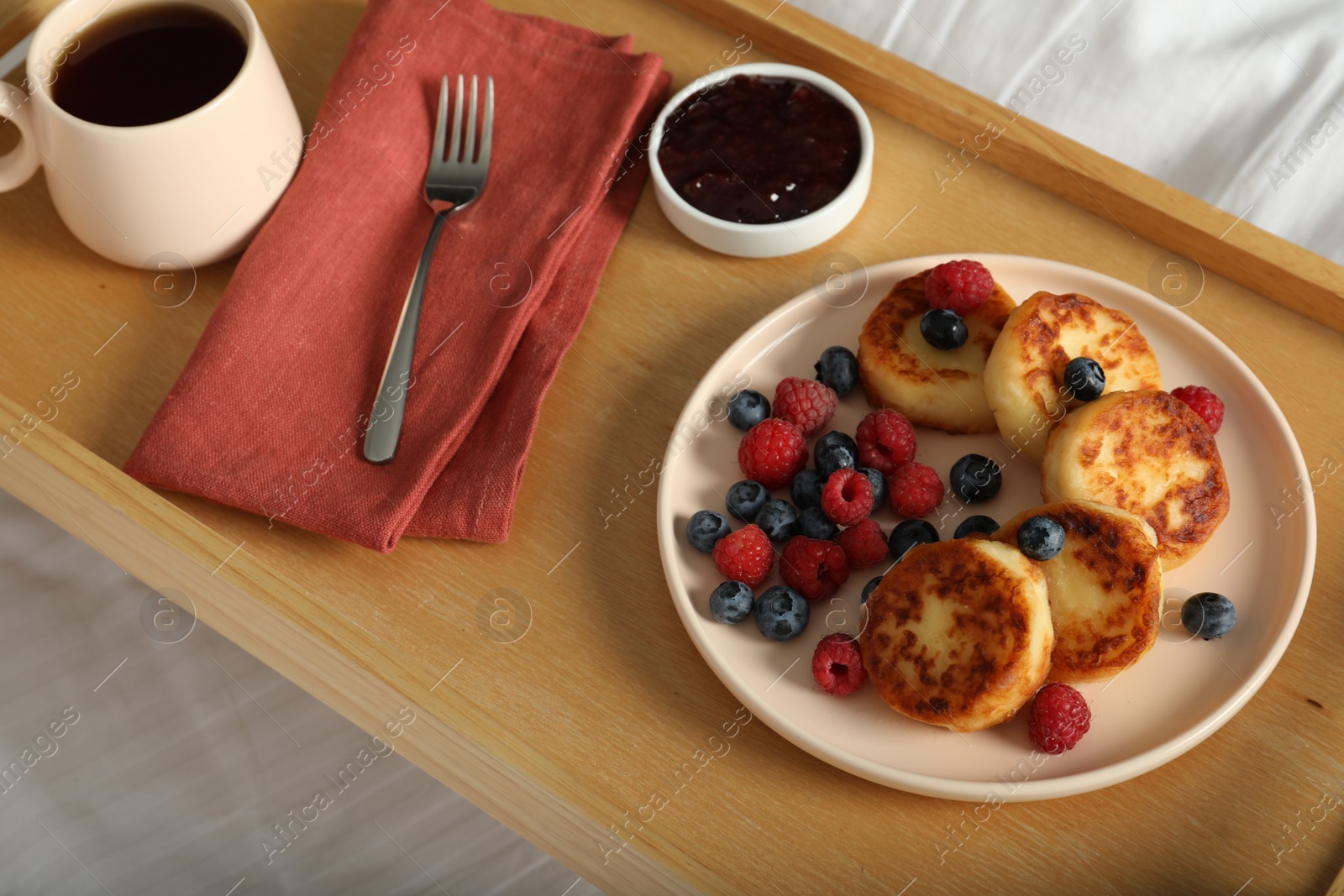 Photo of Delicious cottage cheese pancakes with fresh berries served on bed tray