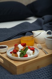 Cottage cheese pancakes with fresh strawberries, sour cream and mint served for breakfast on wooden tray, closeup