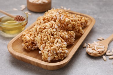 Photo of Plate with puffed rice pieces (kozinaki) on grey table