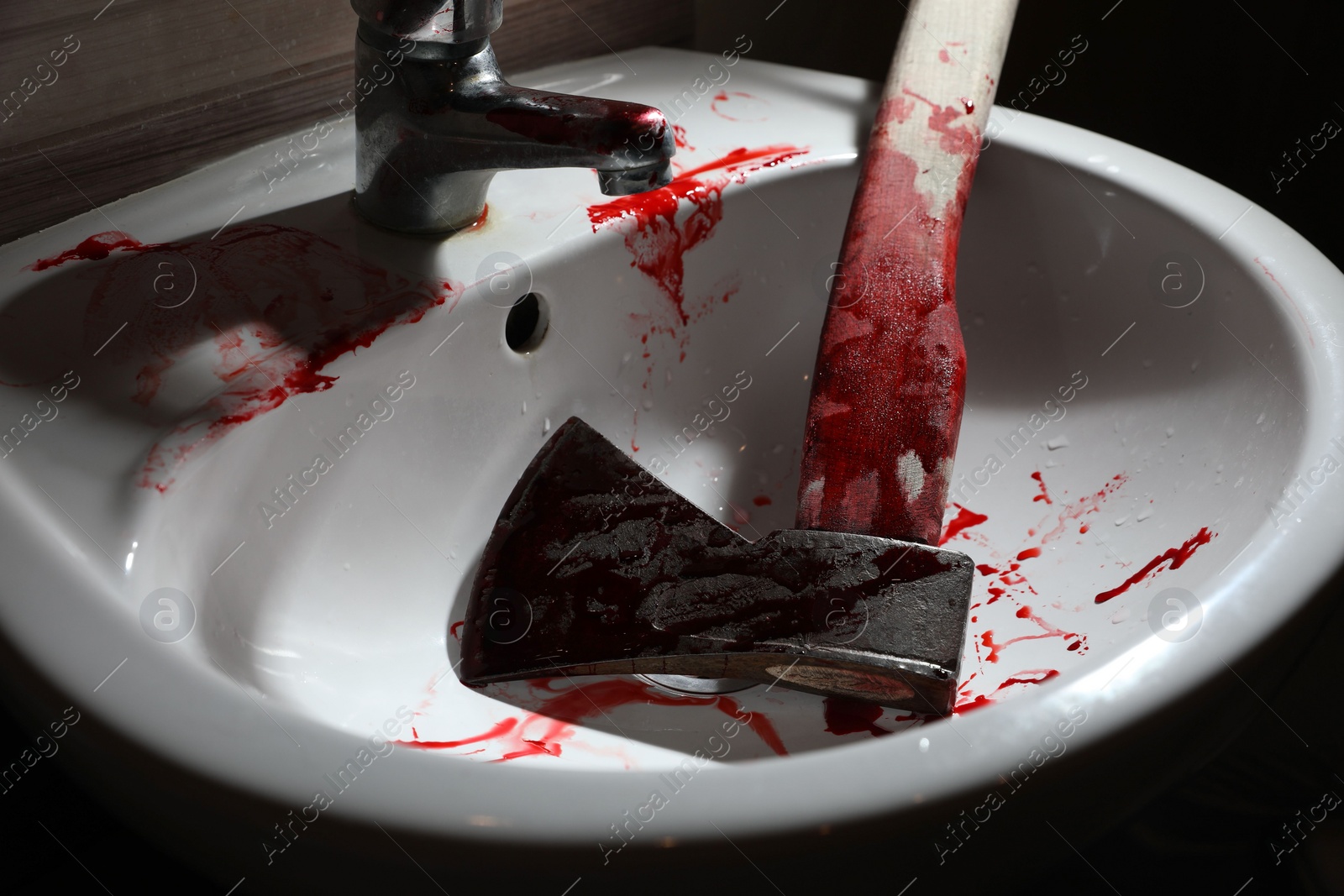 Photo of Axe with blood in sink indoors, closeup